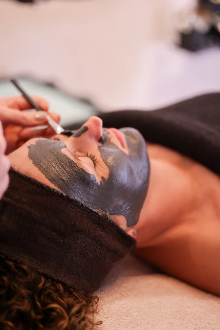Schoonheidsspecialiste brengt met kwastje masker aan op gezicht